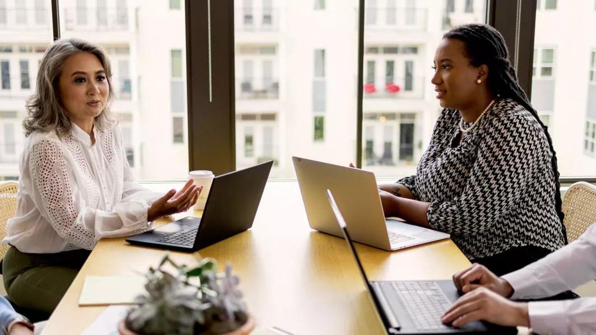 Photo of a diverse group of employees around a conference table having a discussion.