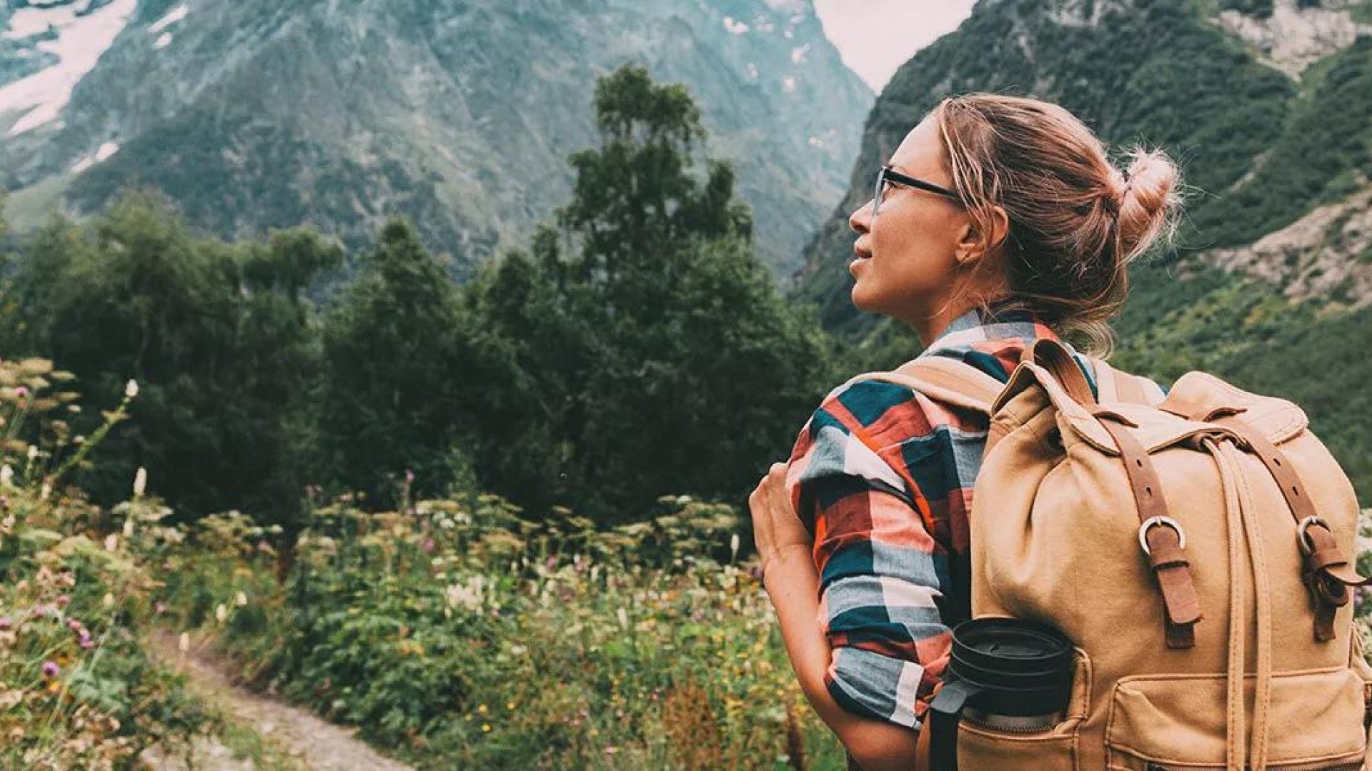 Person hiking on a trail through the mountains.