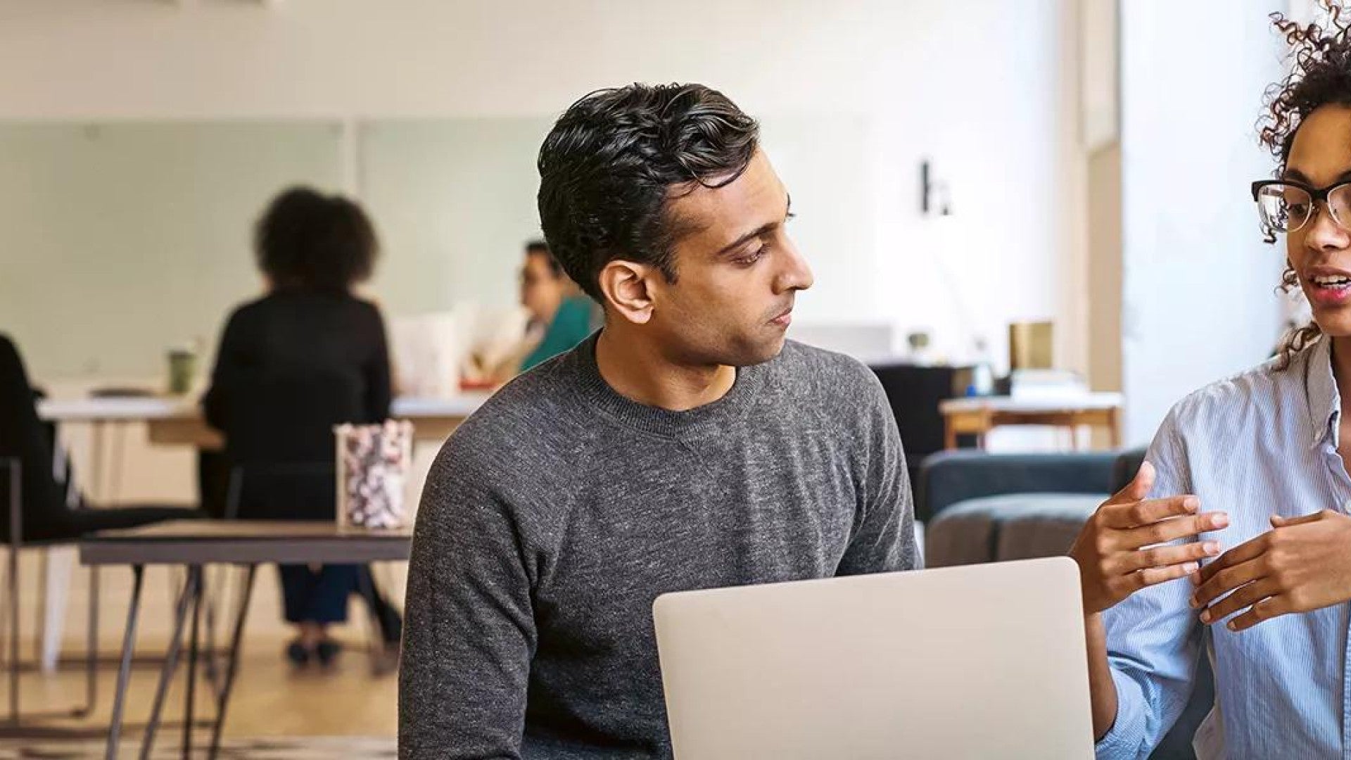 Two employees in an office space discussing defined benefit plans.