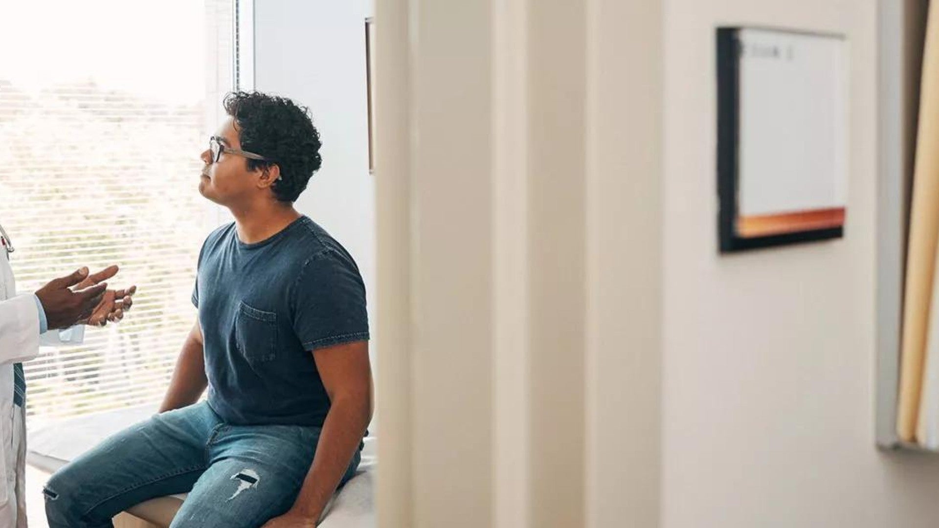 A doctor talking to a patient in an exam room.