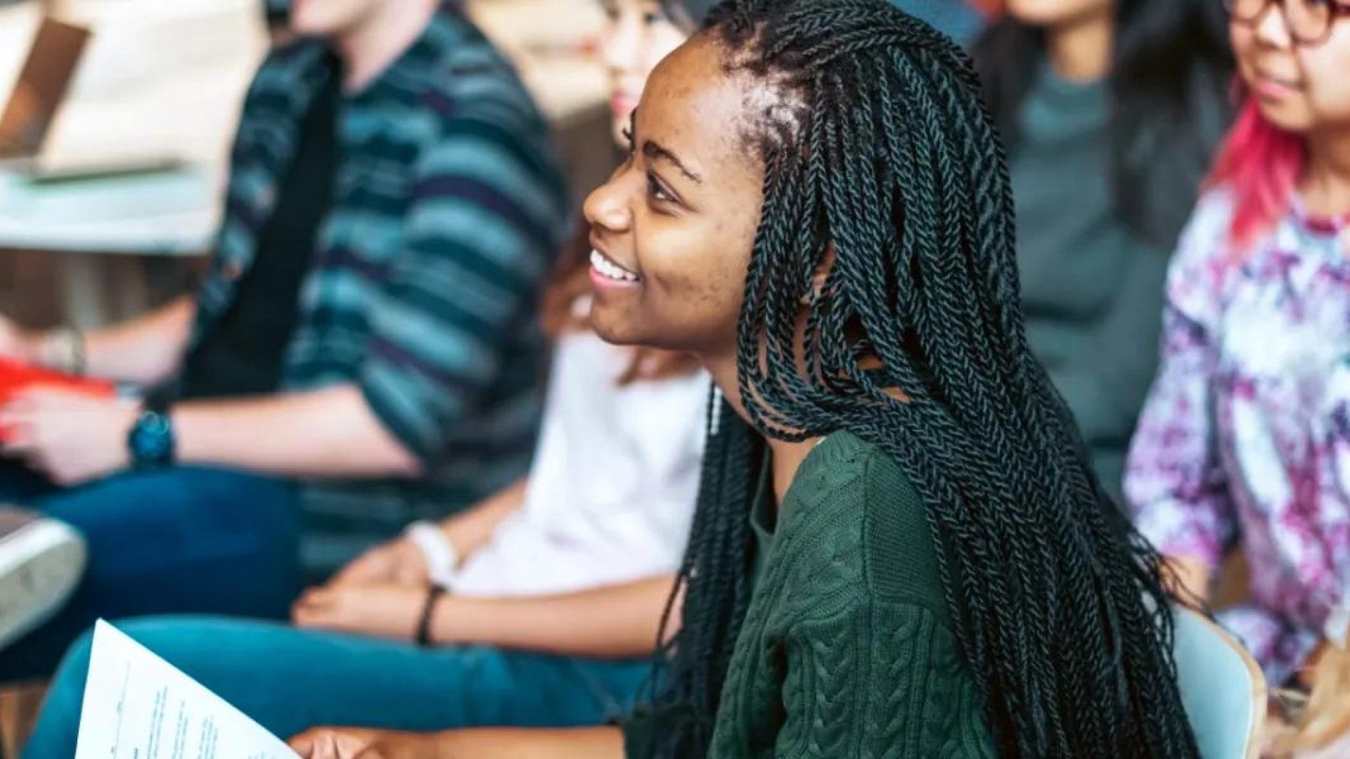 Young woman smiling and listening in a group setting