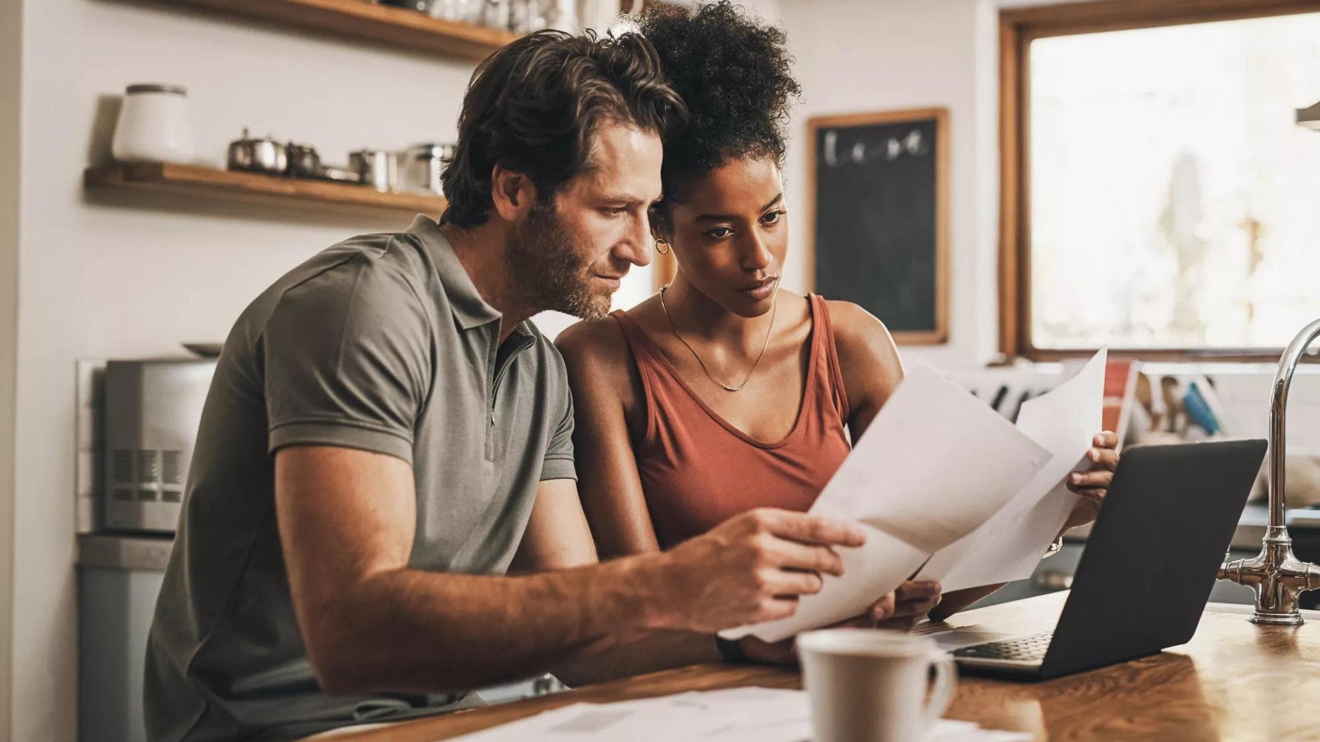 Picture of a couple reviewing paper and digital financial documents.