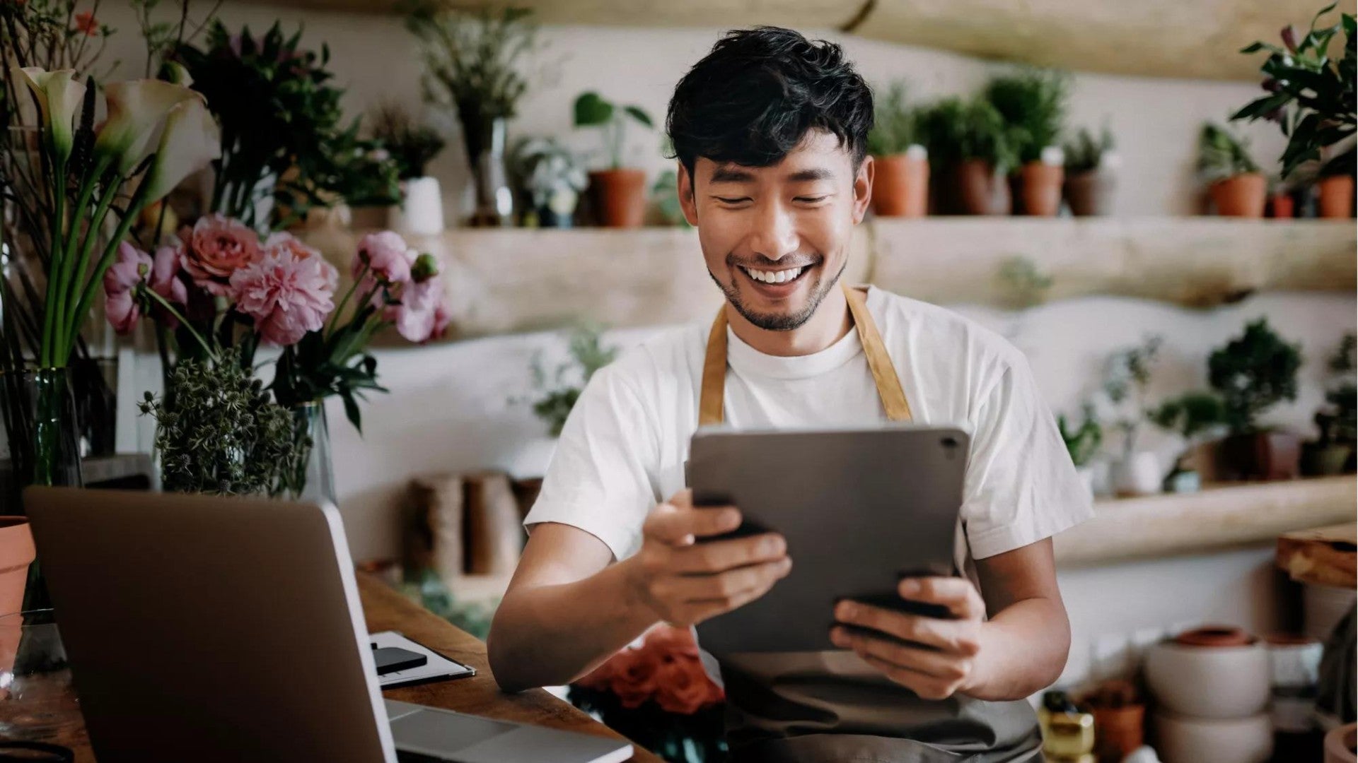 A person in a floral shop reviewing their savings online