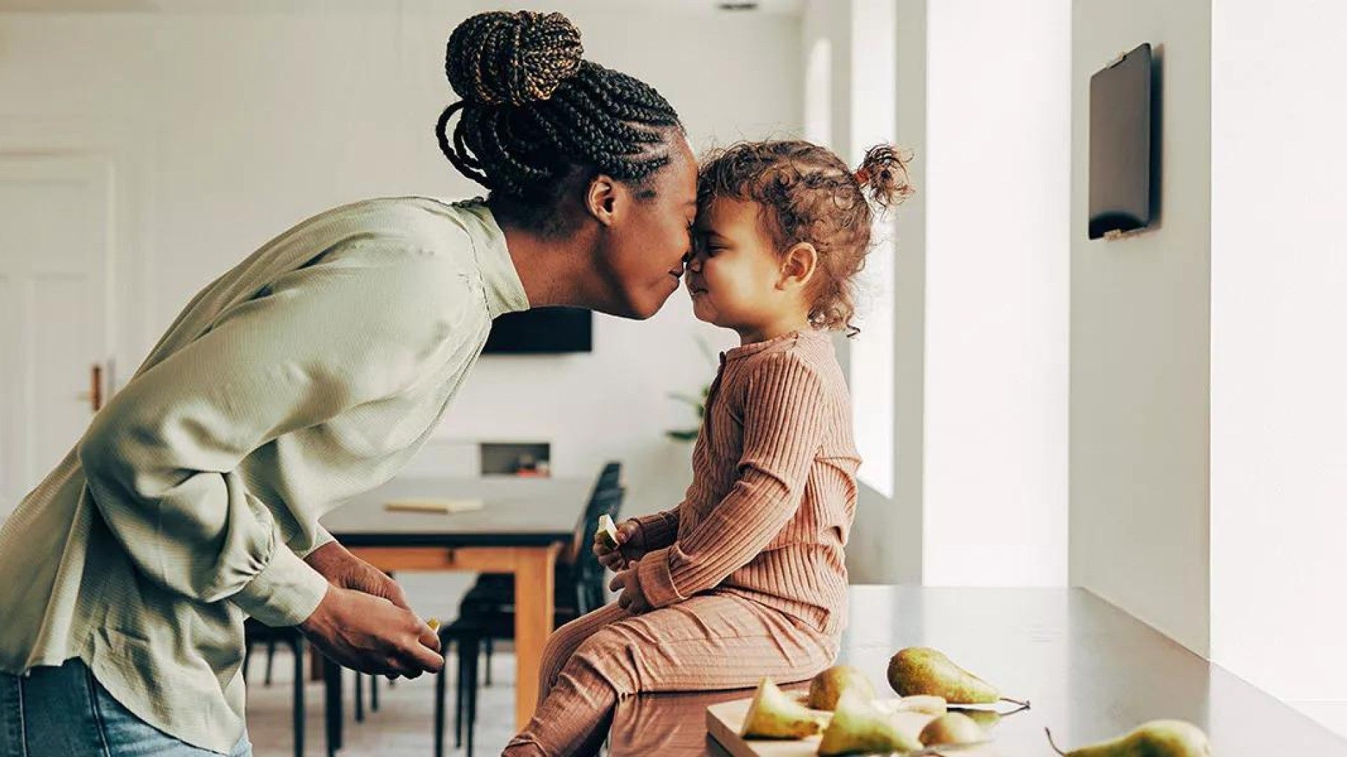 Picture of a mother and her young child playfully touching their noses together.