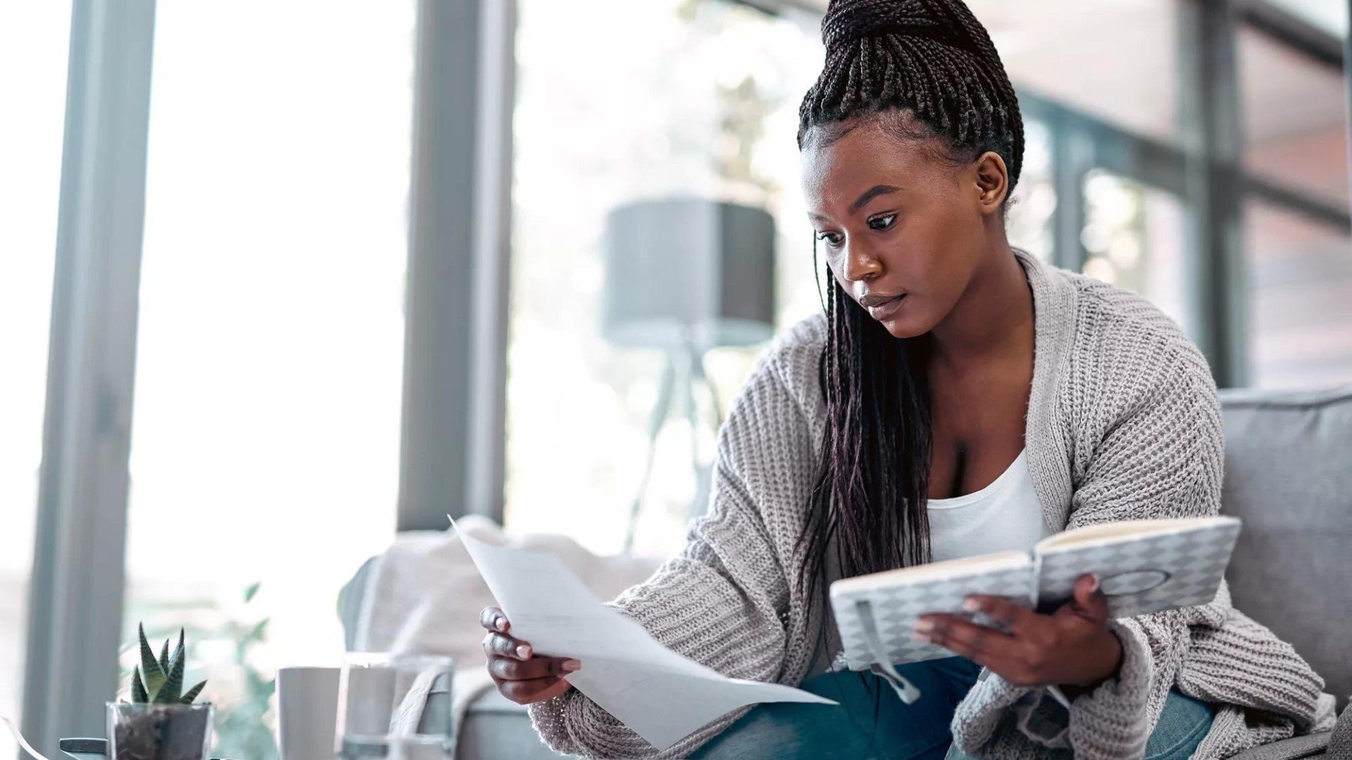 Woman sitting together on a couch working on their budget on a computer