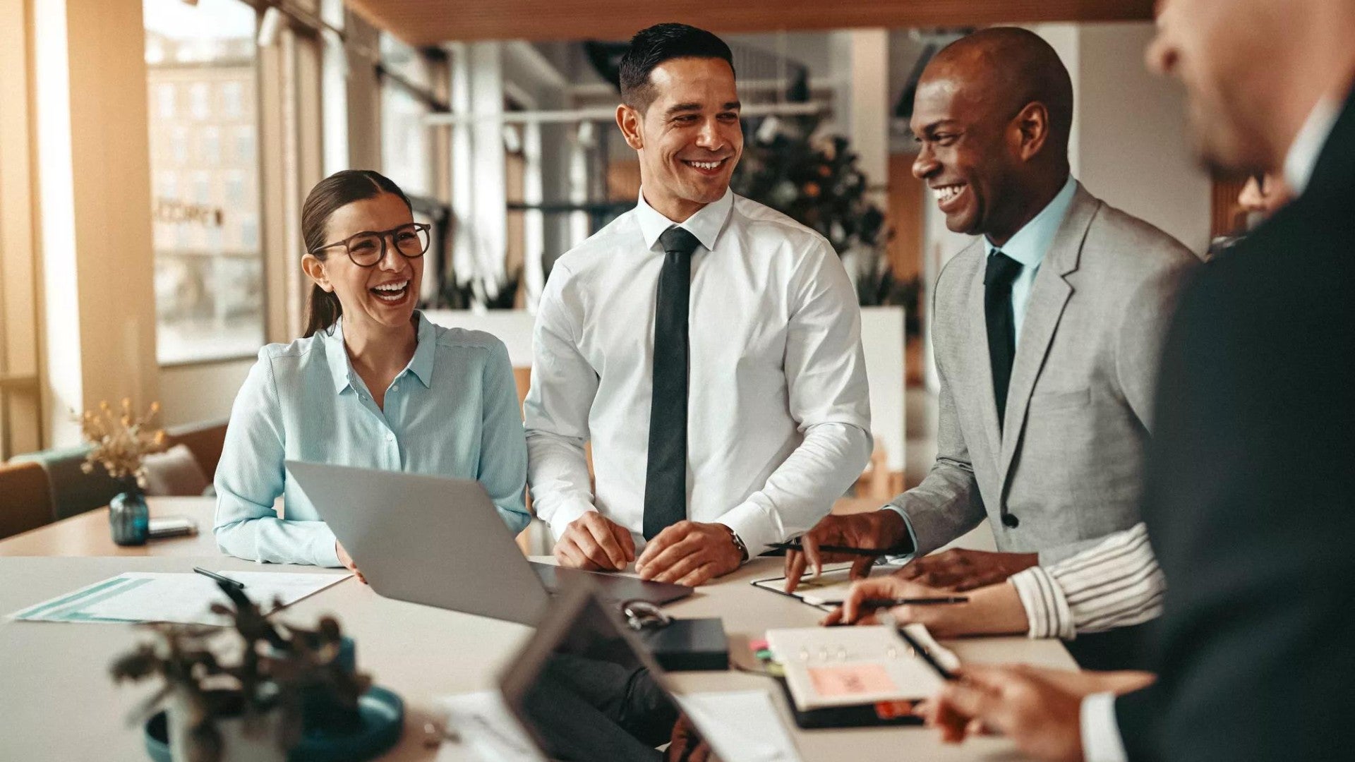 Coworkers standing together around a table discussing work