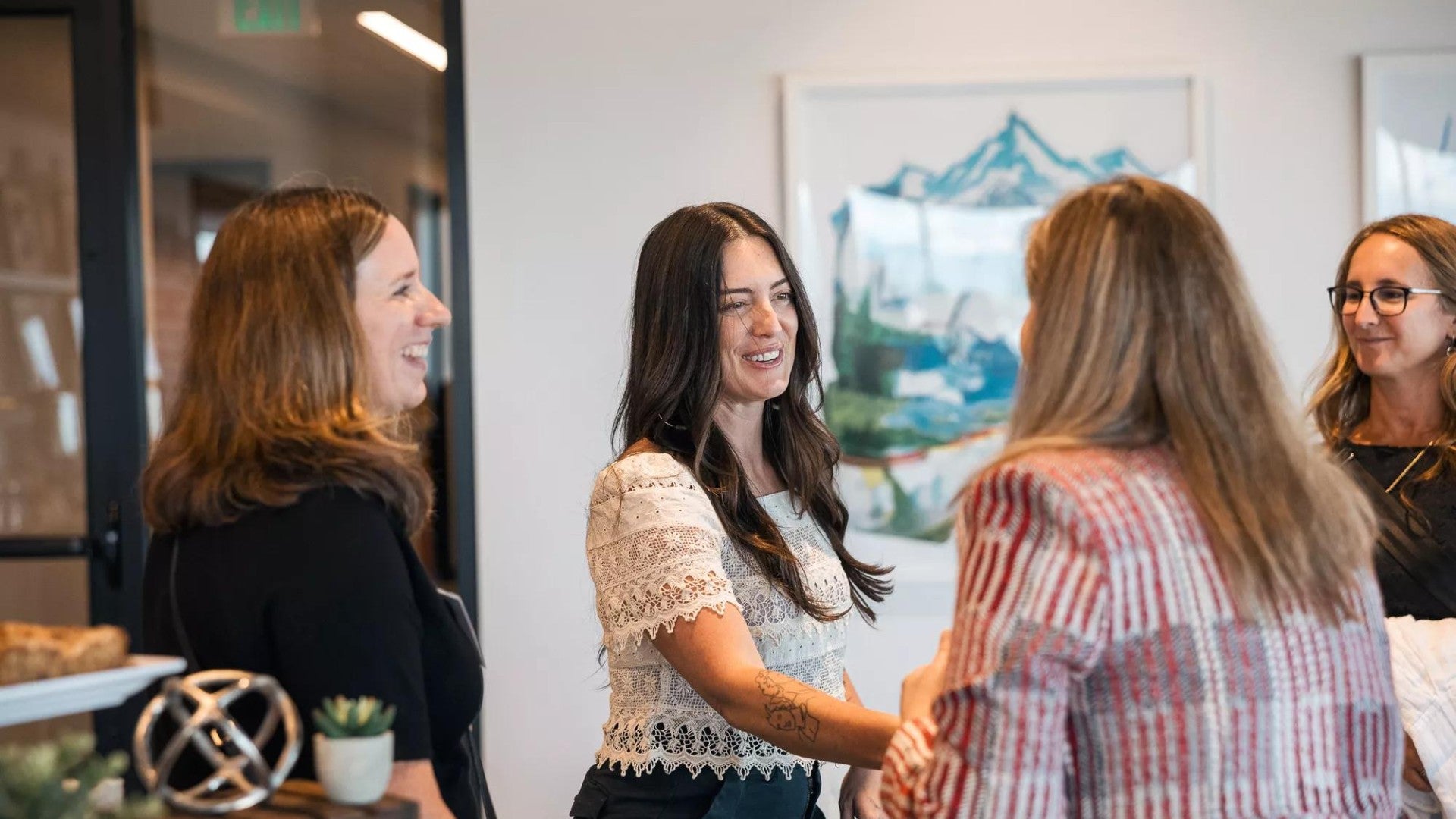 Professional women shaking hands while meeting each other in a small group