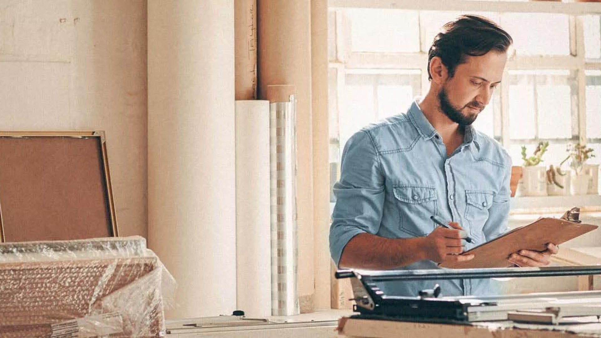 Man at work looking at a clipboard with his savings plan