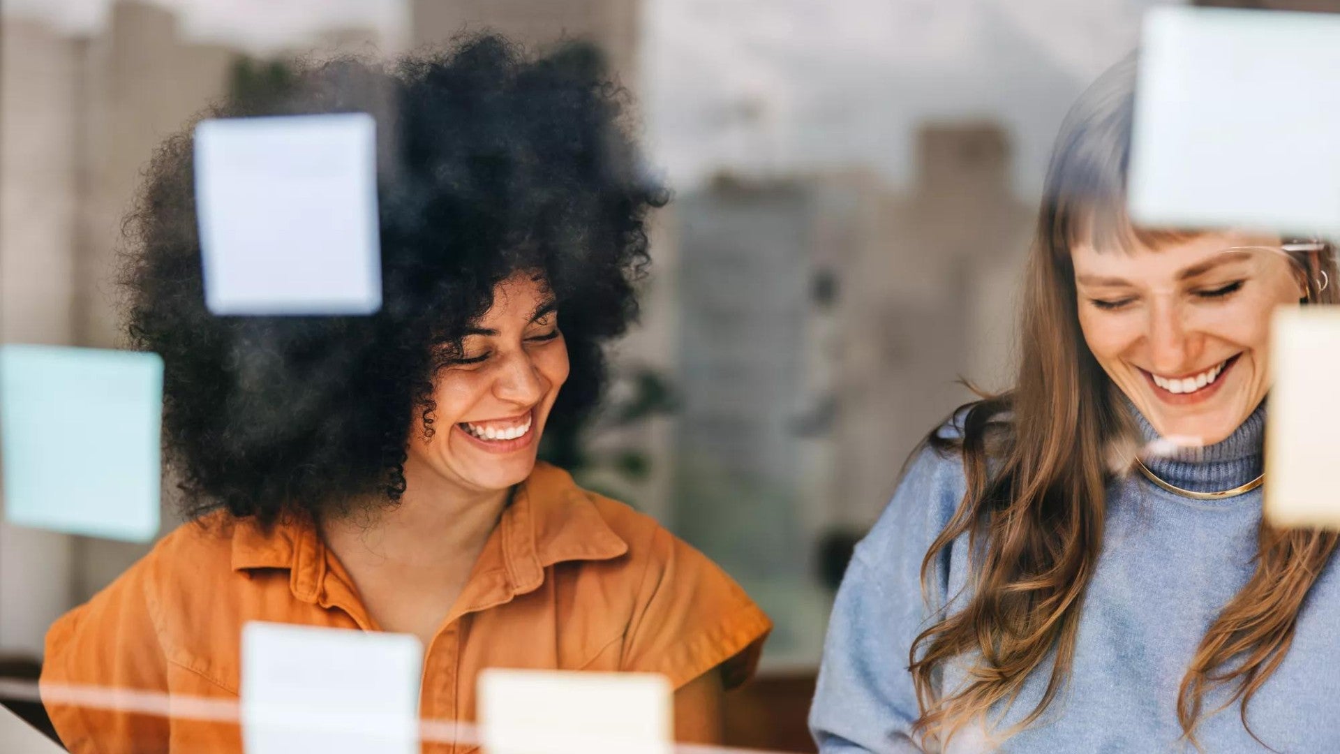 Two woman in an office smiling.