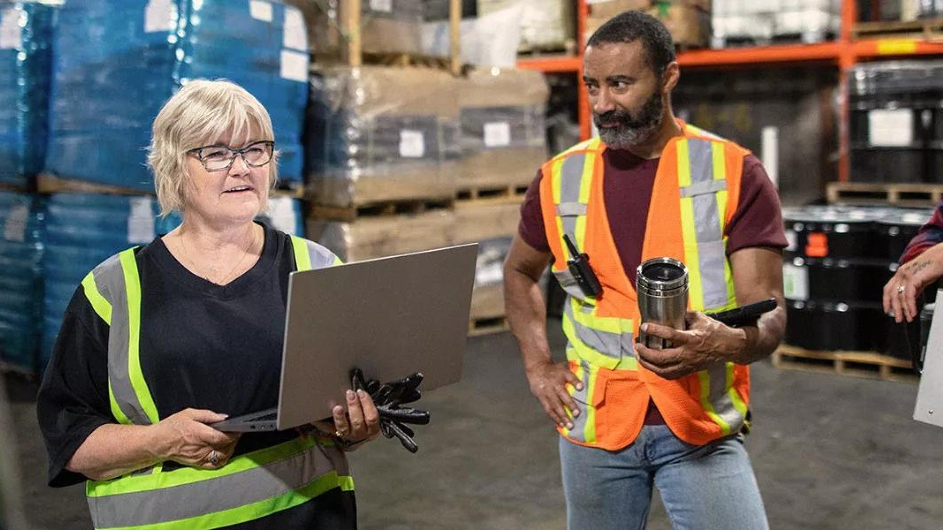 Photo of a small business owner talking to her employees in a warehouse.